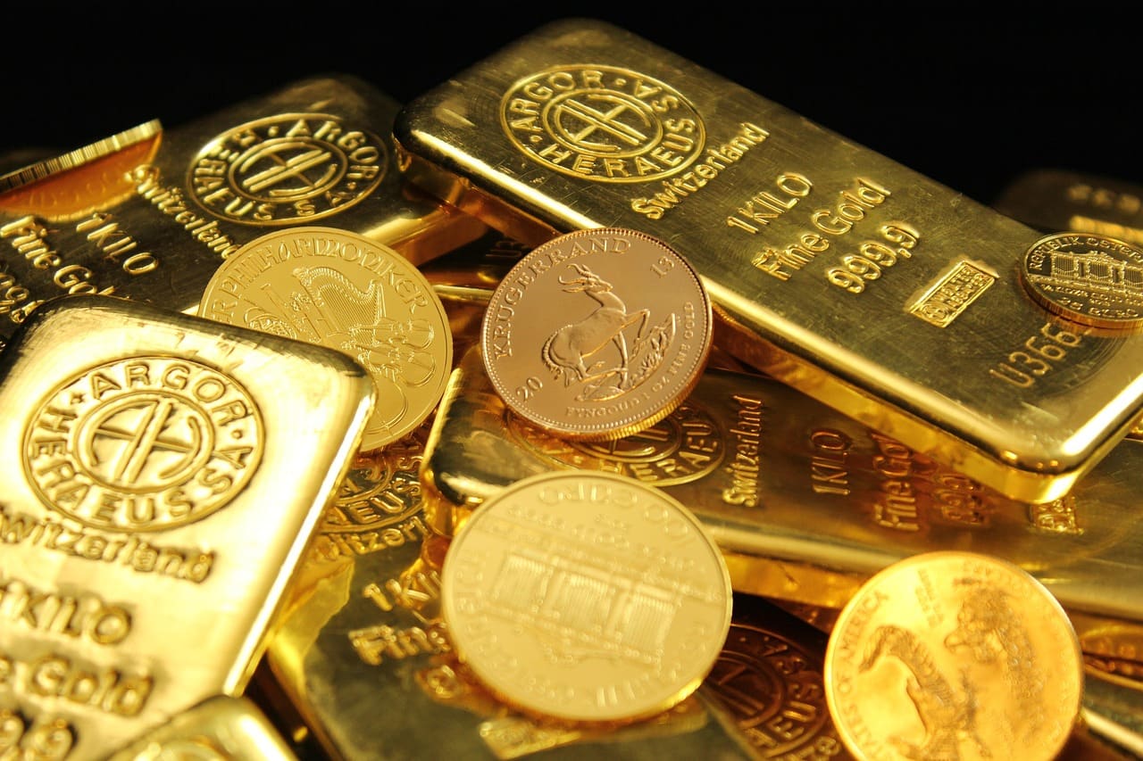 Kilobarrer i gull stemplet 999,9, med gullmynter som Krugerrand og Wiener Philharmoniker oppå